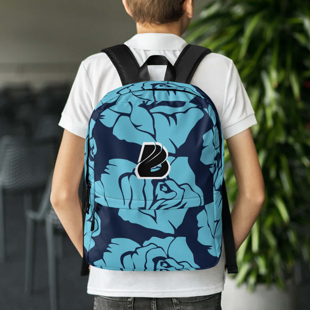 Young person wearing blue floral Rucksack N°4, ideal for daily use or sports, featuring laptop pocket and weather-resistant material.