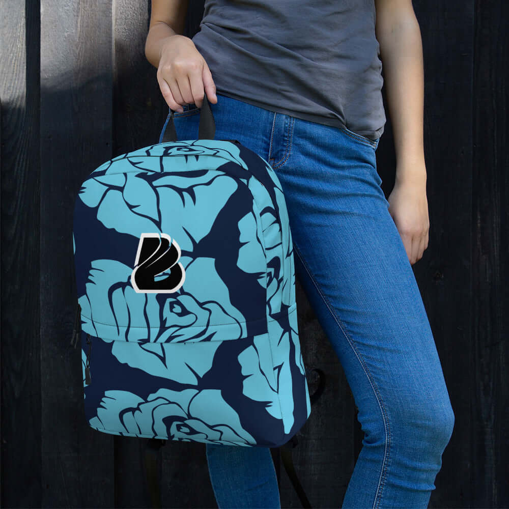 Person holding Rucksack N°4 with blue floral design, ideal for daily use or sports, featuring waterproof material and laptop pocket.