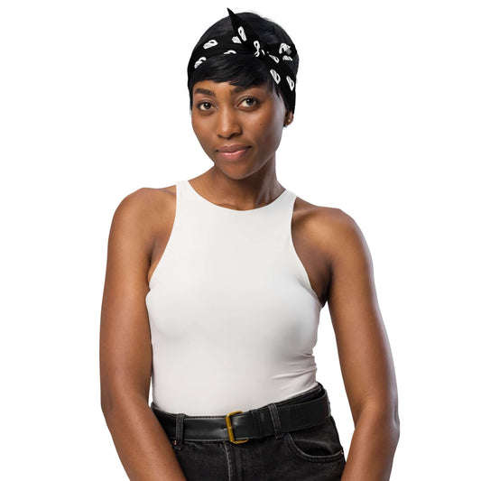 Person wearing Bandana N°0 as a headscarf, stylishly paired with a white tank top and black jeans, showcasing fashion versatility.