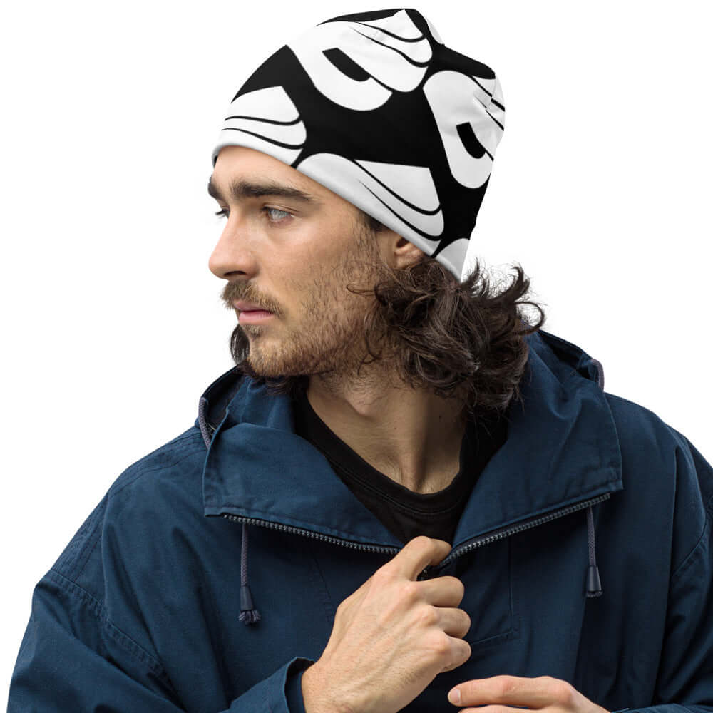 Man wearing Allover-Beanie N°0 in a stylish black and white pattern, perfect for keeping warm and complementing a winter outfit.