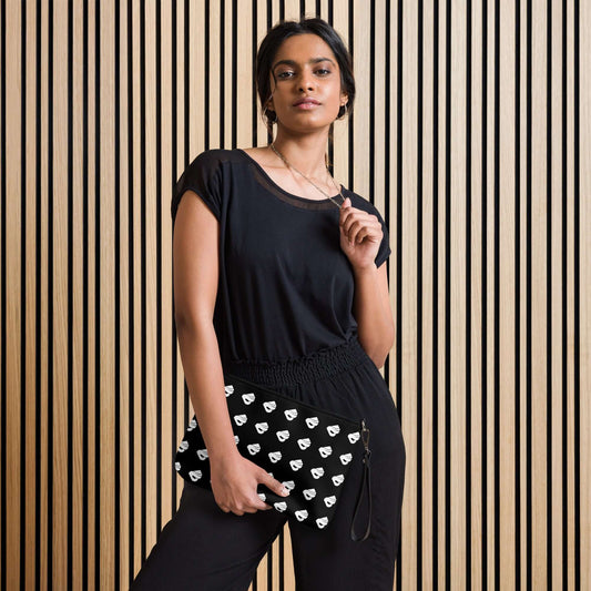 Stylish woman holding Umhängetasche N°0 with black design and heart patterns, showing versatile fashion accessory.