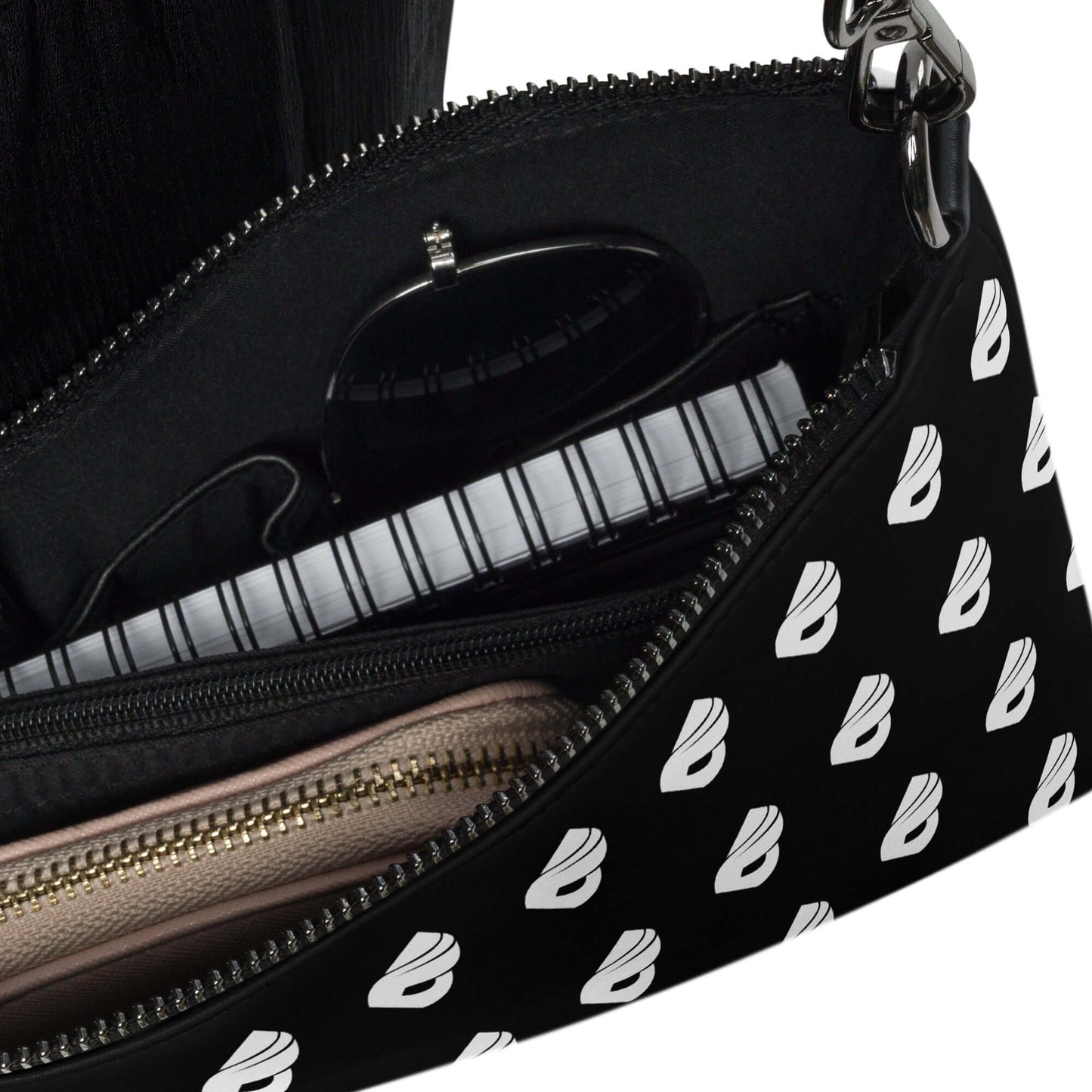 Close-up of the interior of Umhängetasche N°0 showing compartments for organized storage of essentials. Black pattern design.