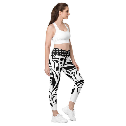 Woman wearing V-Bund-Leggings mit Taschen N°0 in black and white print, showcasing side pockets and flattering design.