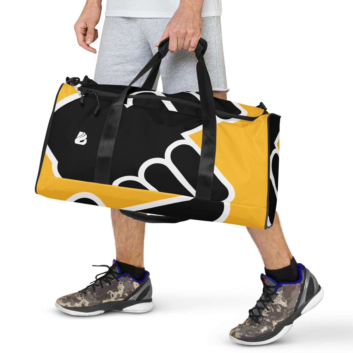 Man carrying Weekender N°24, a spacious duffel bag in black and yellow design with adjustable shoulder straps, perfect for travel or gym.