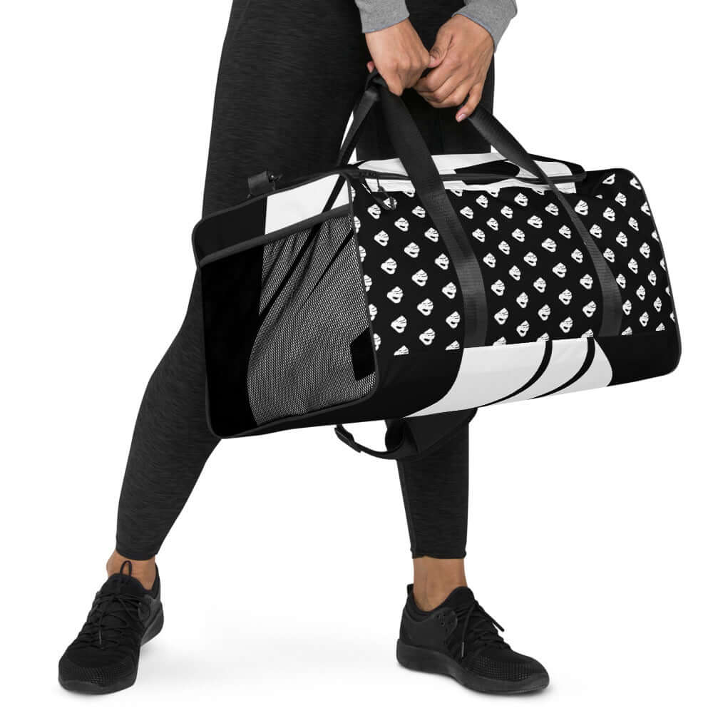 Person carrying a stylish Weekender N°0 bag with black and white pattern, perfect for travel, errands, or gym, featuring multiple pockets.