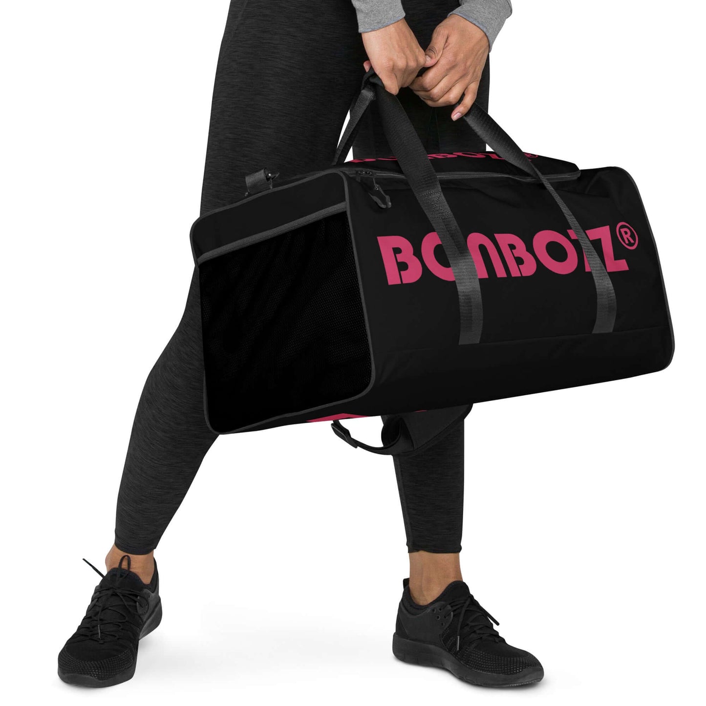 Person carrying black and pink Weekender N°22 bag with adjustable shoulder straps and multiple compartments.