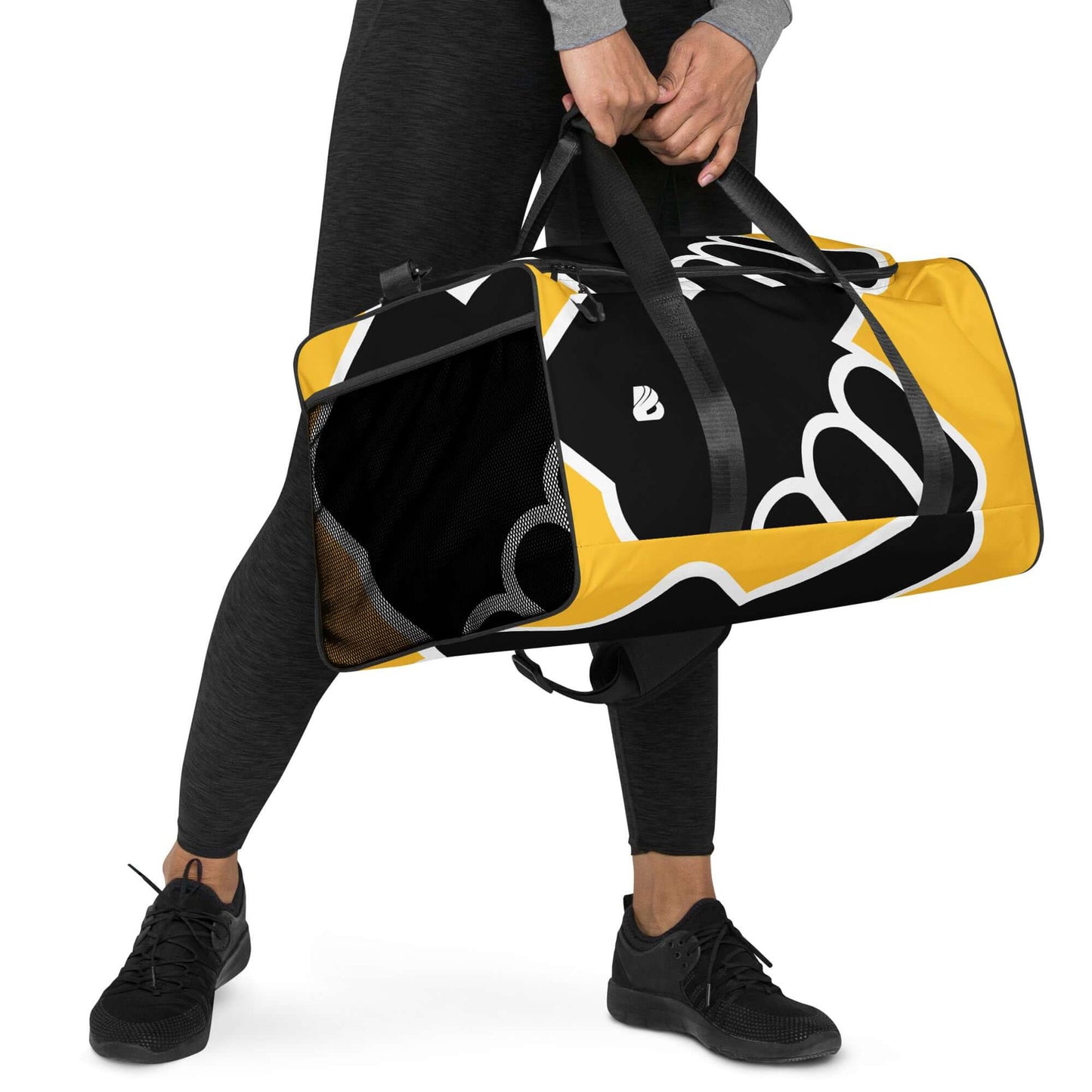 Person carrying Weekender N°24 travel bag with adjustable shoulder straps, perfect for travel or gym use, black and yellow design.