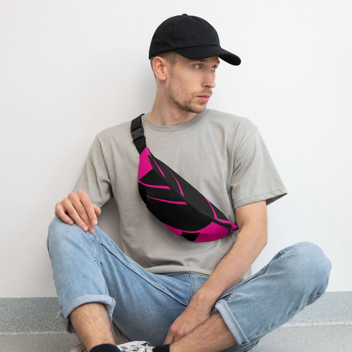 Alt Tag: Man wearing Gürteltasche N°25 in pink and black, sitting casually with a stylish and adjustable strap, ideal for travel and festivals.