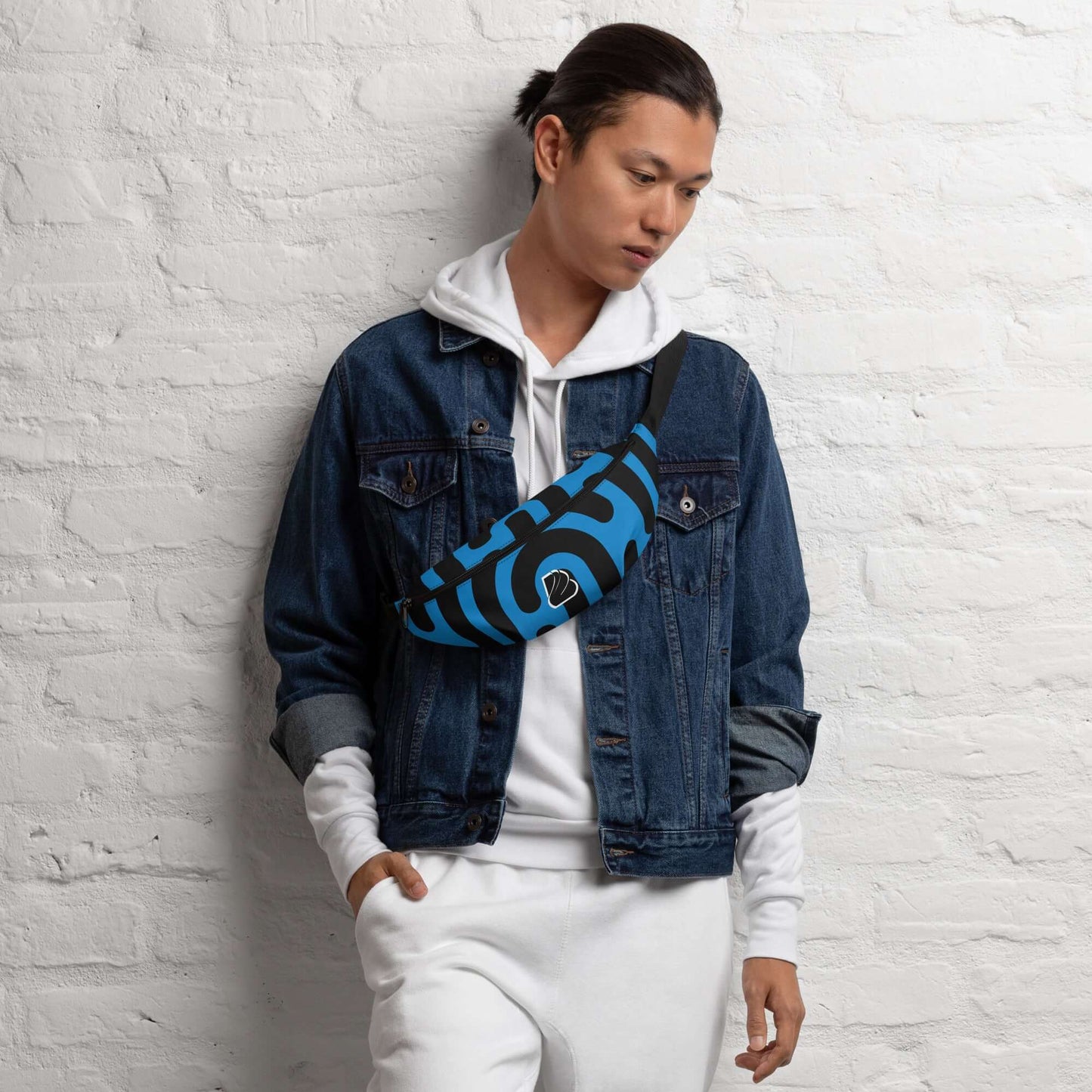 Mann trägt blaue Gürteltasche N°27 über der Schulter, kombiniert mit einer Jeansjacke und Hoodie.