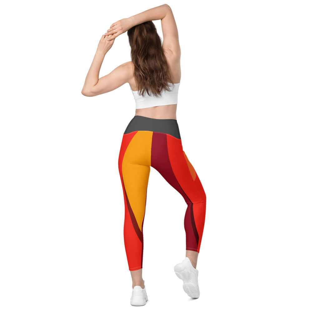 Back view of woman wearing Leggings mit Taschen N°0 with colorful red and orange pattern, demonstrating four-way stretch fit.