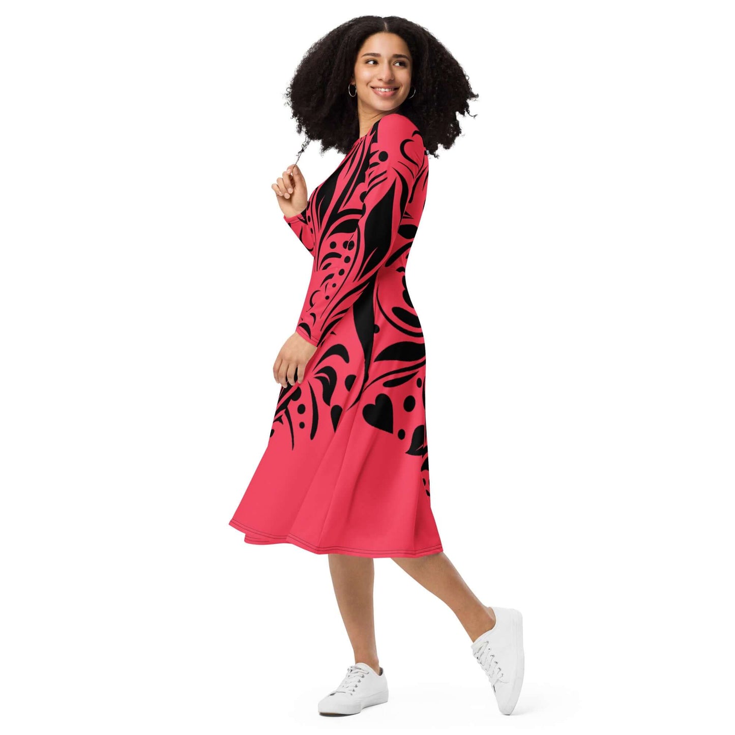 Langärmliges Midikleid mit Allover-Druck N°1 in pink und schwarz, getragen von einer lächelnden Frau, zeigt taillierte Passform und Taschen.