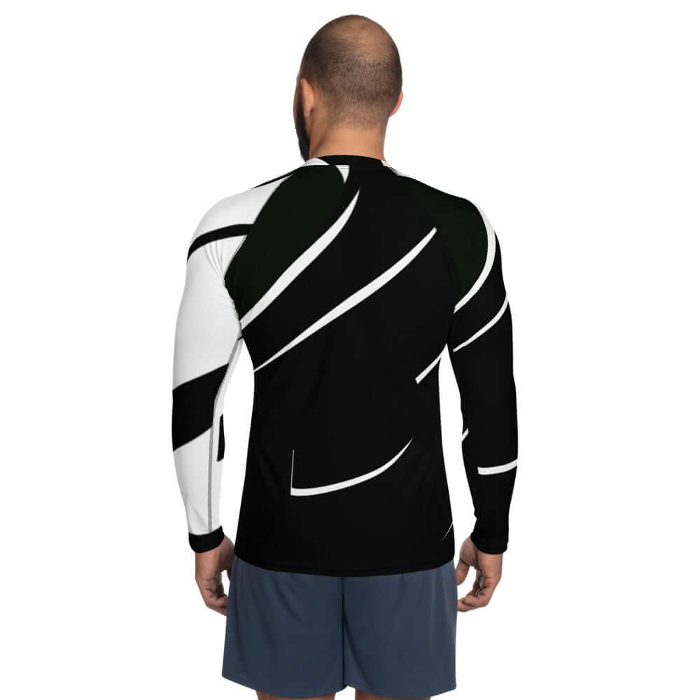 Back view of man wearing Herren-Rash-Guard N°3 with black and white pattern, long sleeves, ergonomic seams for sun and weather protection.