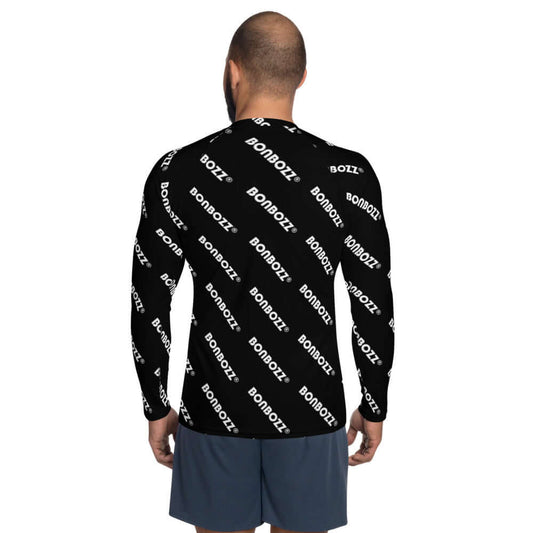 Back view of a man wearing Herren-Rash-Guard N°25, long-sleeve black top with white text, ideal for UV protection and comfort.