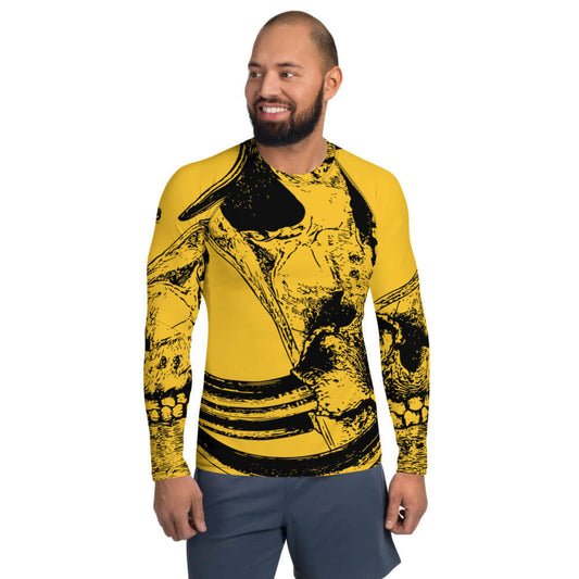 Herren-Rash-Guard N°6 in yellow with black graphic design, long sleeves, worn by man standing and smiling.