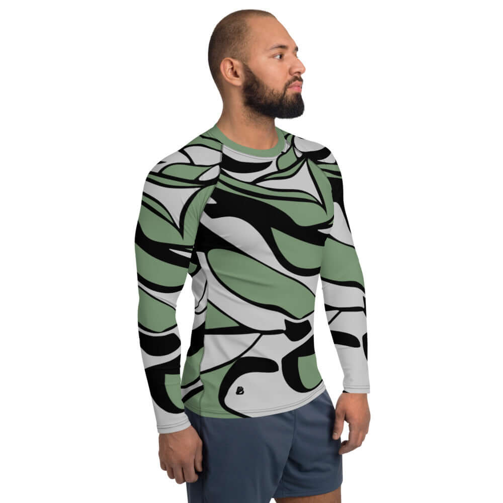 Herren-Rash-Guard N°11 with abstract green and black pattern worn by man.