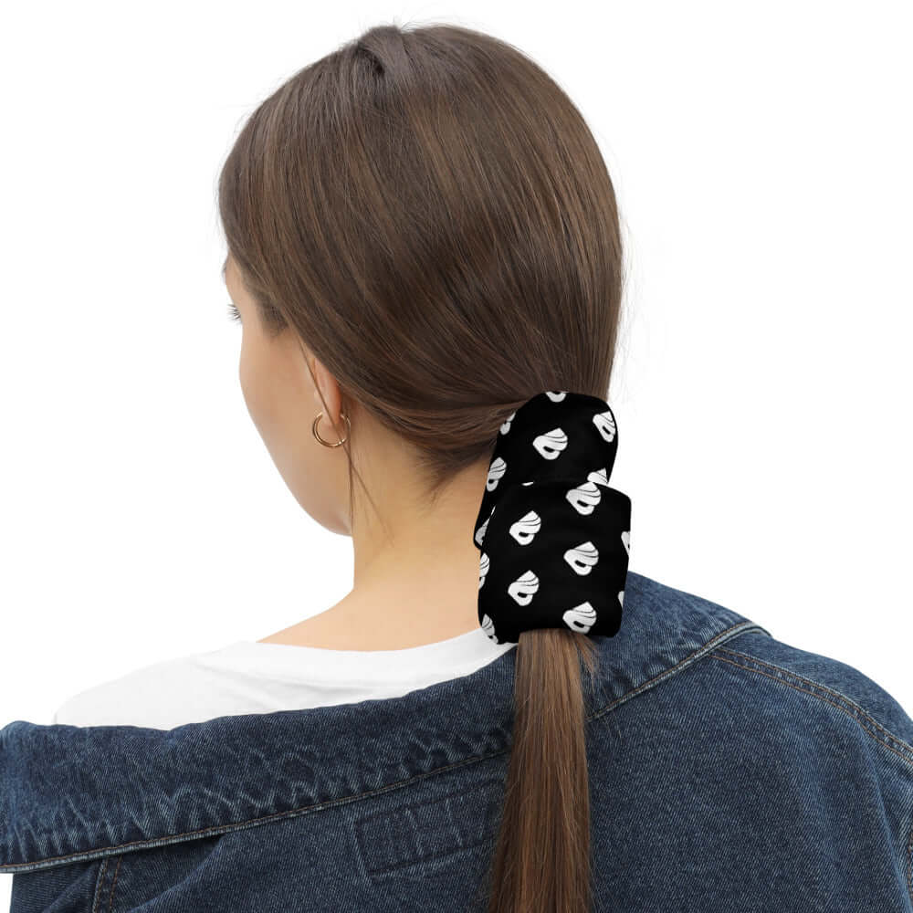 Person wearing Multifunktionstuch N°0 as a hair accessory, black with white pattern, demonstrating versatile usage.