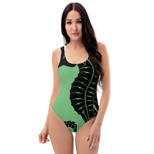 Model wearing Einteiliger Badeanzug N°0 in green with black leaf design, featuring a flattering fit for all body types.