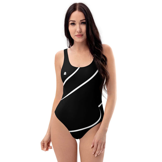 Einzelne Frau im eleganten Einteiliger Badeanzug N°13 am Strand, figurbetontes Design, glatter schwarzer Stoff, ideal für Meer oder Pool.