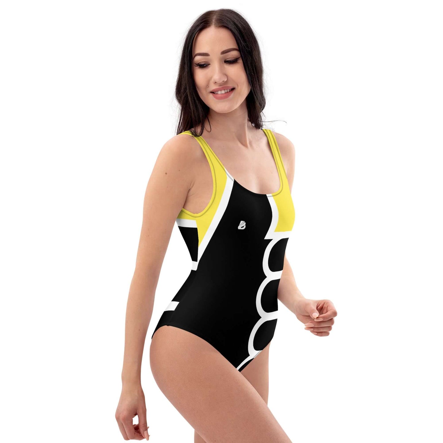 Frau trägt Einteiliger Badeanzug N°19 am Strand, schmeichelhaftes Design in Schwarz und Gelb, perfekter Badeanzug für alle Figuren