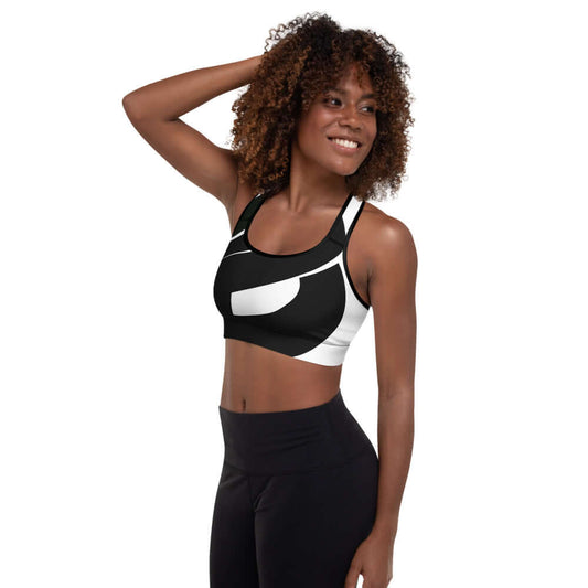 Woman wearing Gepolsterter Sport-BH N°0, black and white sports bra, perfect for workouts and comfort.