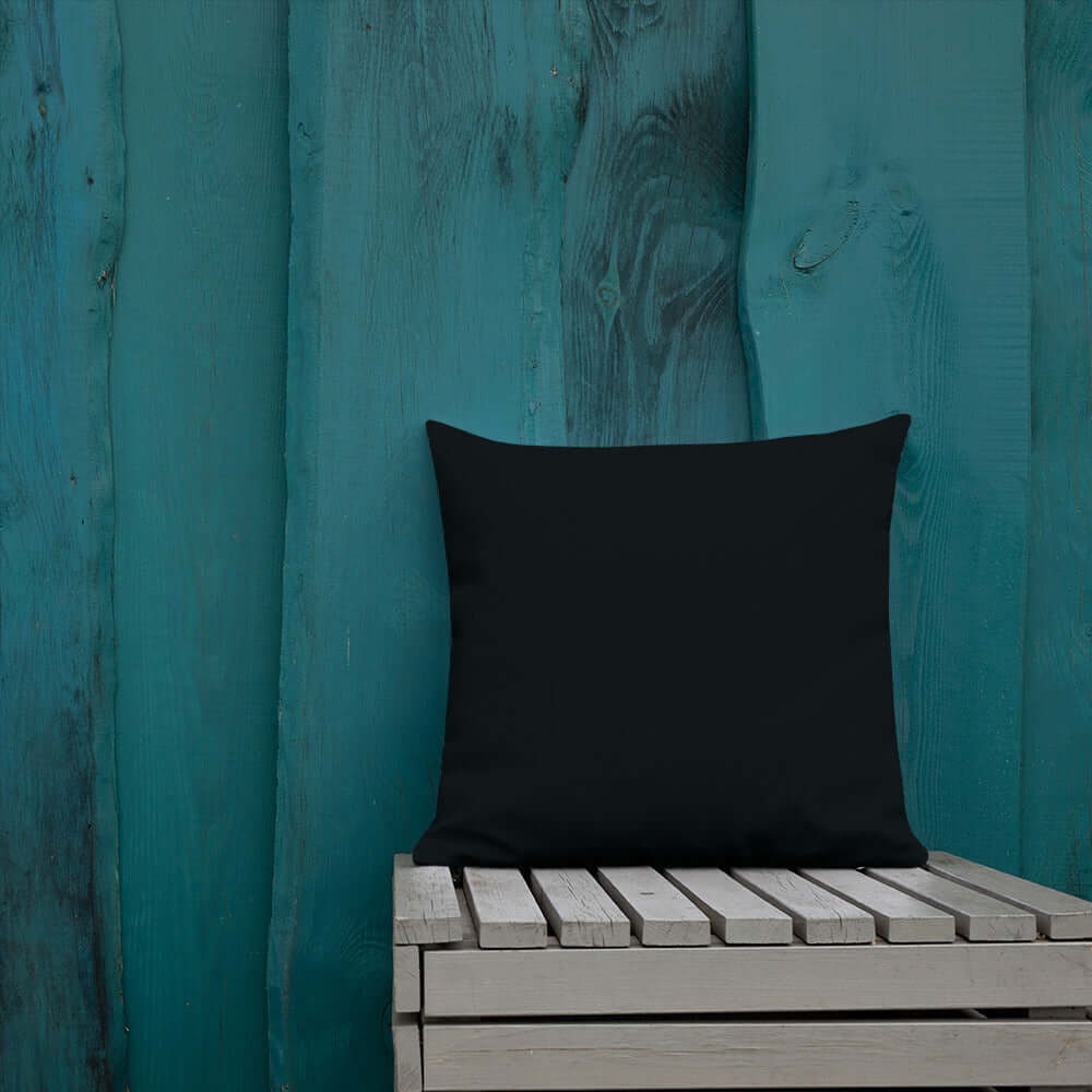 Premium-Kissen N°0 on a wooden chair with teal background, luxurious home decor pillow, form-stable insert, modern aesthetic.