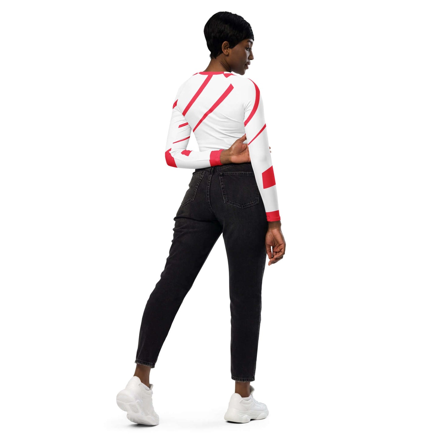 Model wearing a recycled long sleeve crop top with allover print, paired with black jeans and white sneakers.