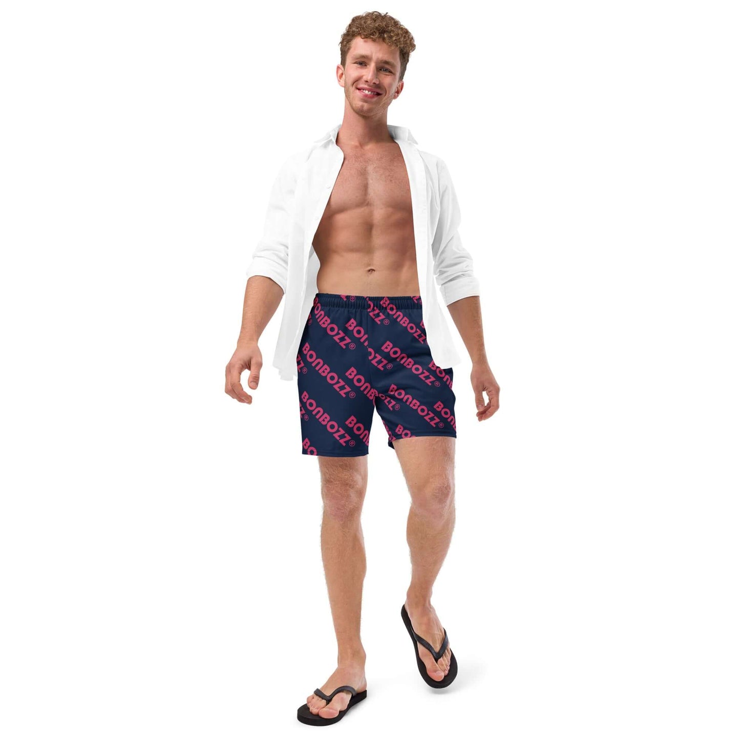 Man wearing Herren-Badehosen N°9, navy swim trunks with logo, showcasing summer style and comfort.