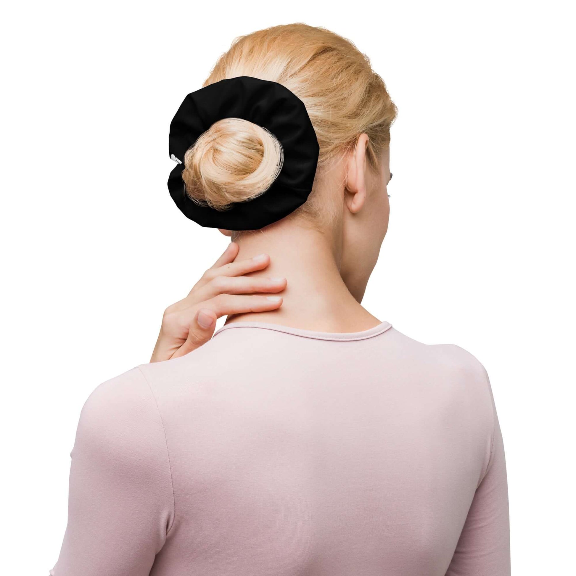 Woman wearing black Scrunchie N°2 in a bun, showcasing stylish hair accessory.