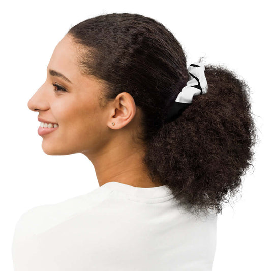 Woman wearing Scrunchie N°0 in black and white, adding style to her curly hair. Made from leftover materials, soft and stretchy - ideal for all day wear.
