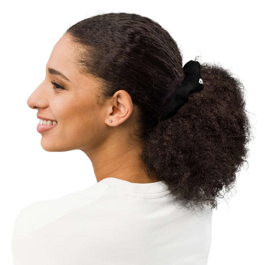 Woman with curly hair wearing Scrunchie N°2, black, adding a stylish touch to her look. Soft, stretchy fabric with eco-friendly materials.
