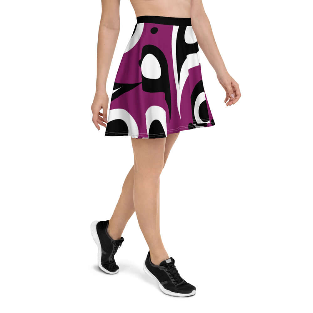 Woman wearing Skater-Rock N°3, a soft, flared mid-thigh skirt with elastic waistband, featuring a bold purple and black pattern.