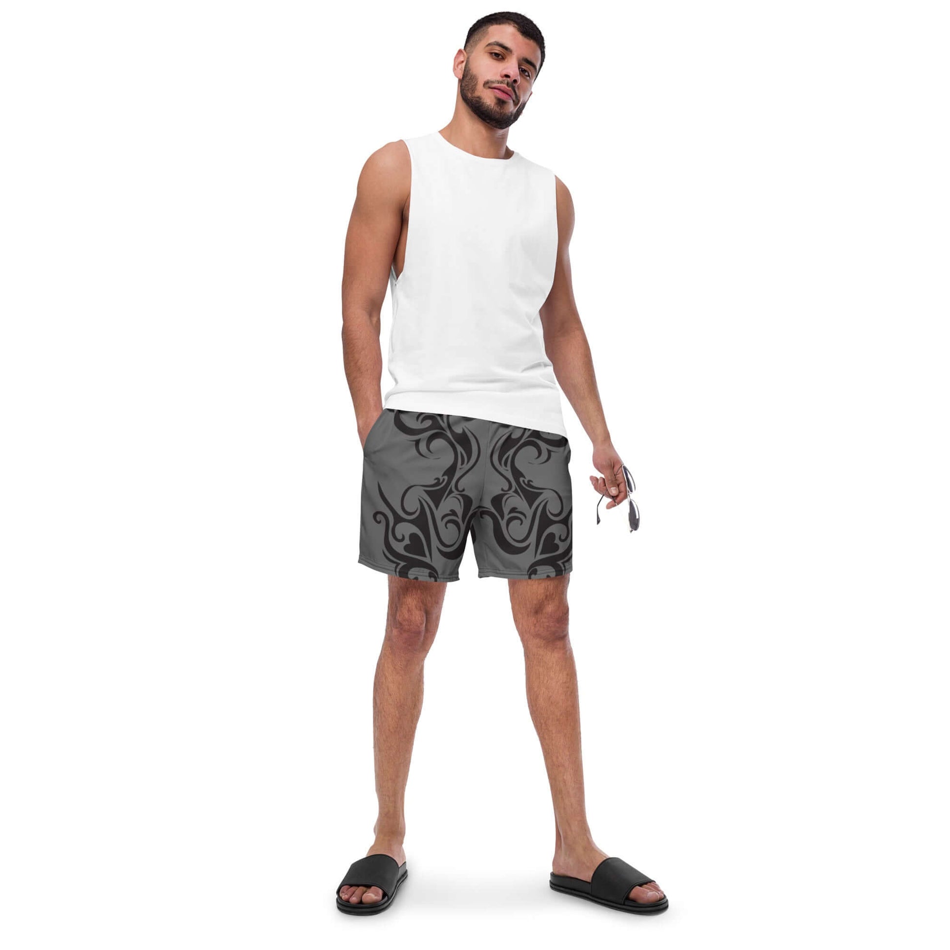 Man wearing Herren-Badehosen N°0 with quick-dry and breathable features, holding sunglasses. Stylish swimwear for summer days.