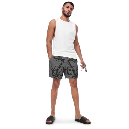 Man wearing Herren-Badehosen N°0 with quick-dry and breathable features, holding sunglasses. Stylish swimwear for summer days.