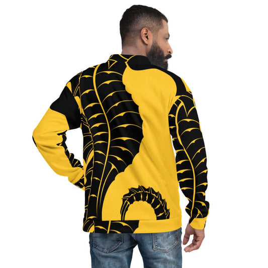 Rear view of model wearing Unisex Bomberjacke N°14 with bold yellow and black graphic design.