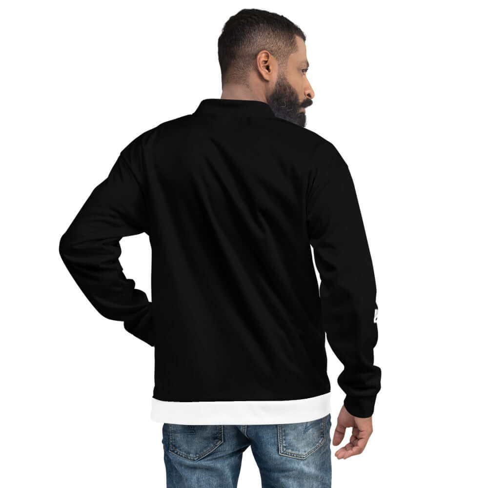 Rückansicht eines Mannes, der die Unisex Bomberjacke N°19 in Schwarz trägt, kombiniert mit Jeans. Perfekt für jeden Kleiderschrank.