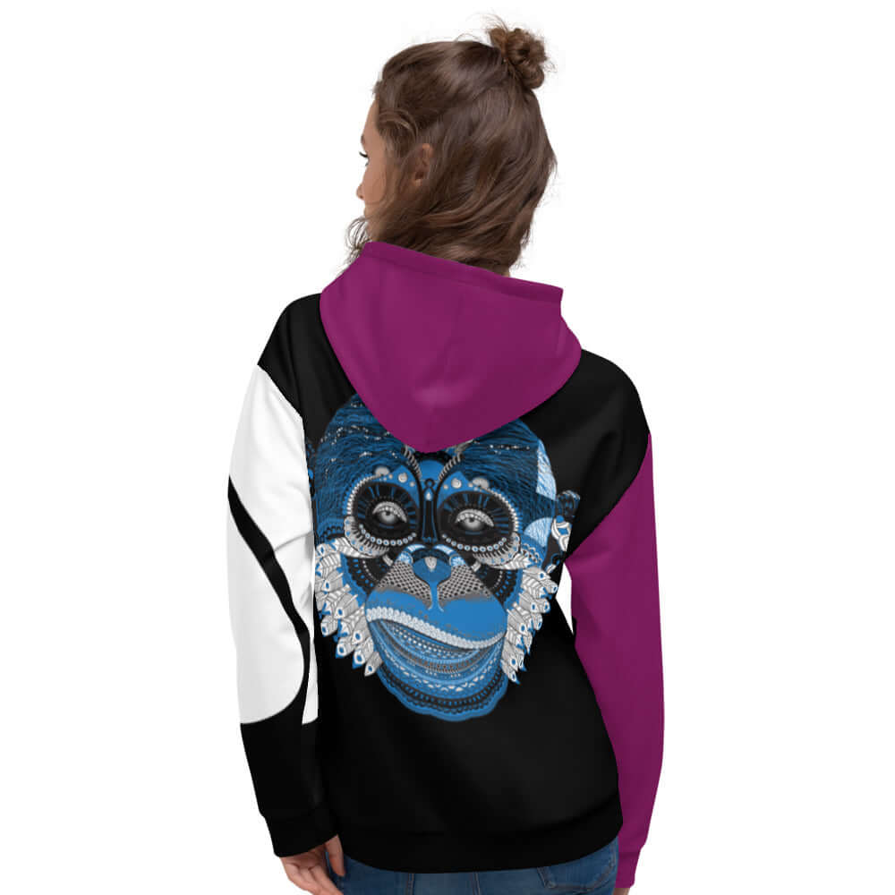 Woman wearing Unisex-Kapuzenpullover N°3 with vibrant monkey print on the back, showcasing cozy and stylish design.