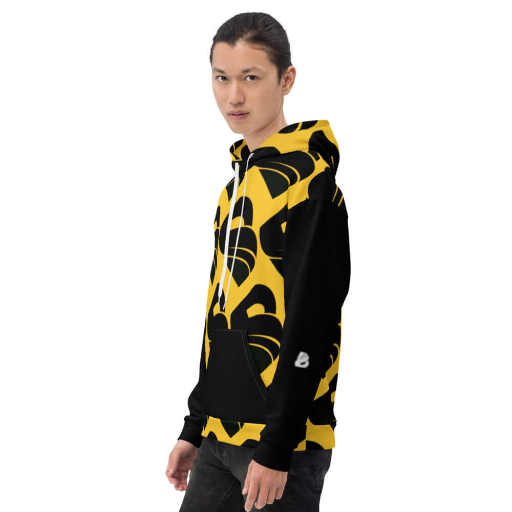 Young person wearing Unisex-Kapuzenpullover N°30, featuring a vibrant black and yellow pattern, ideal for cozy, stylish evenings.