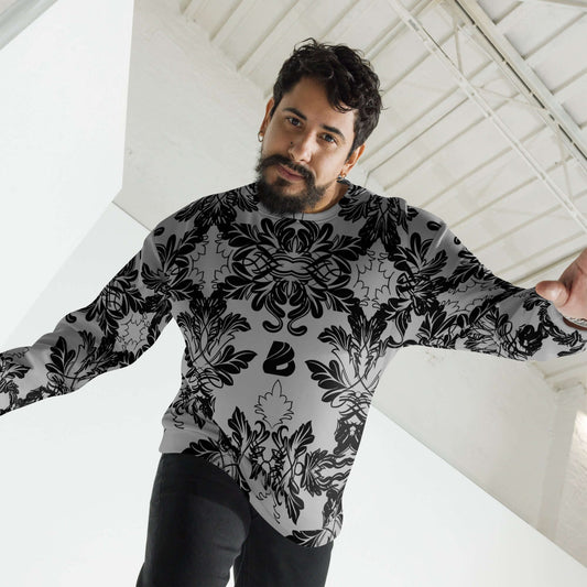 Man wearing Unisex-Pullover N°28 with black intricate design, showcasing handcrafted quality in a bright room.