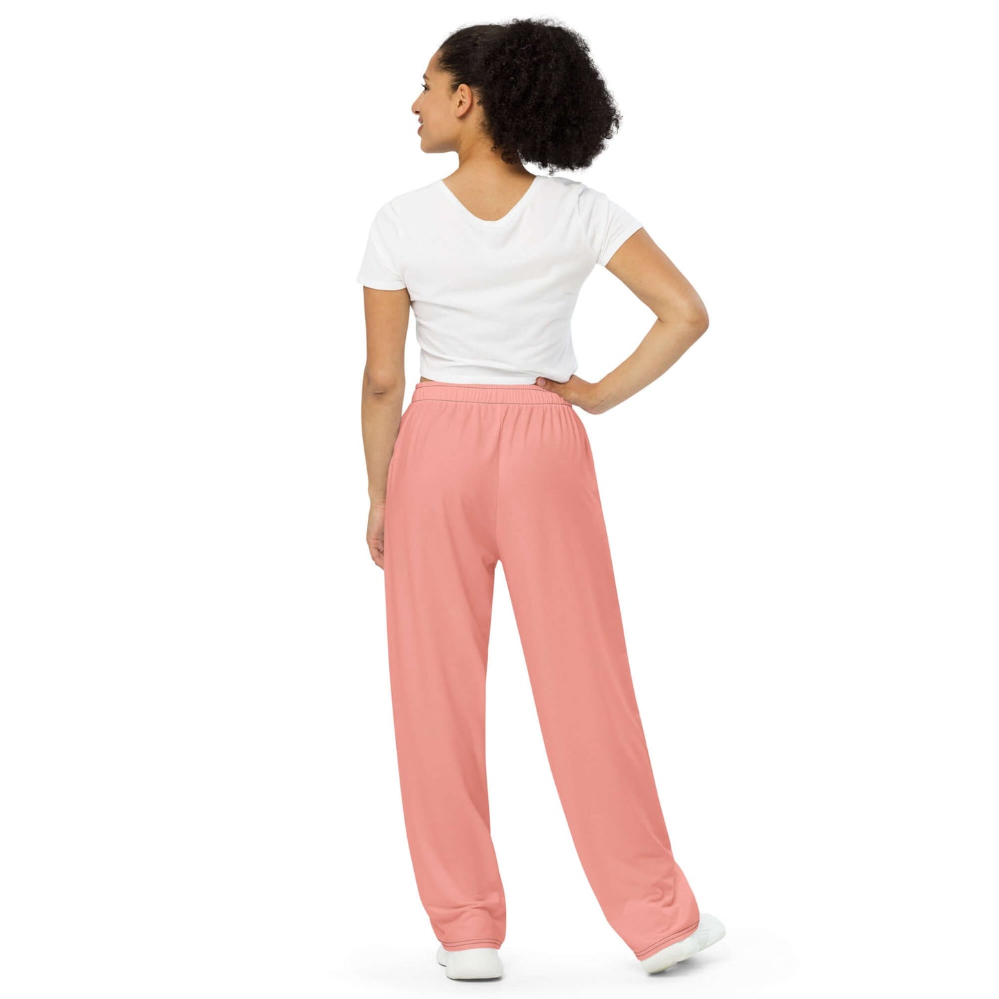 Model wearing Unisex-Hose mit weiten Beinen und Allover-Druck N°0 in pink, showcasing loose fit and side pockets.