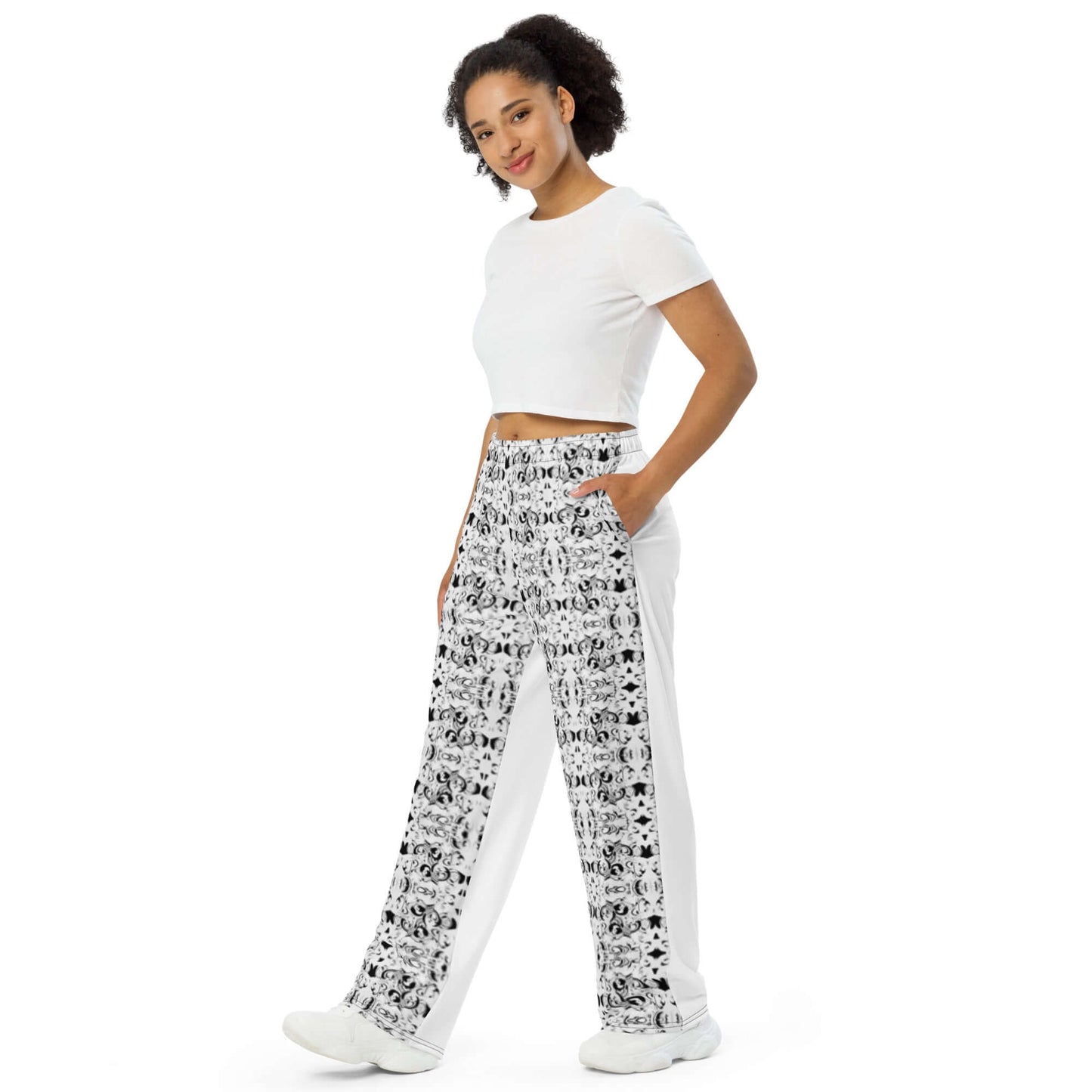 Person wearing Unisex-Hose mit weiten Beinen N°0 in white with a printed pattern, featuring practical side pockets and an elastic waistband.