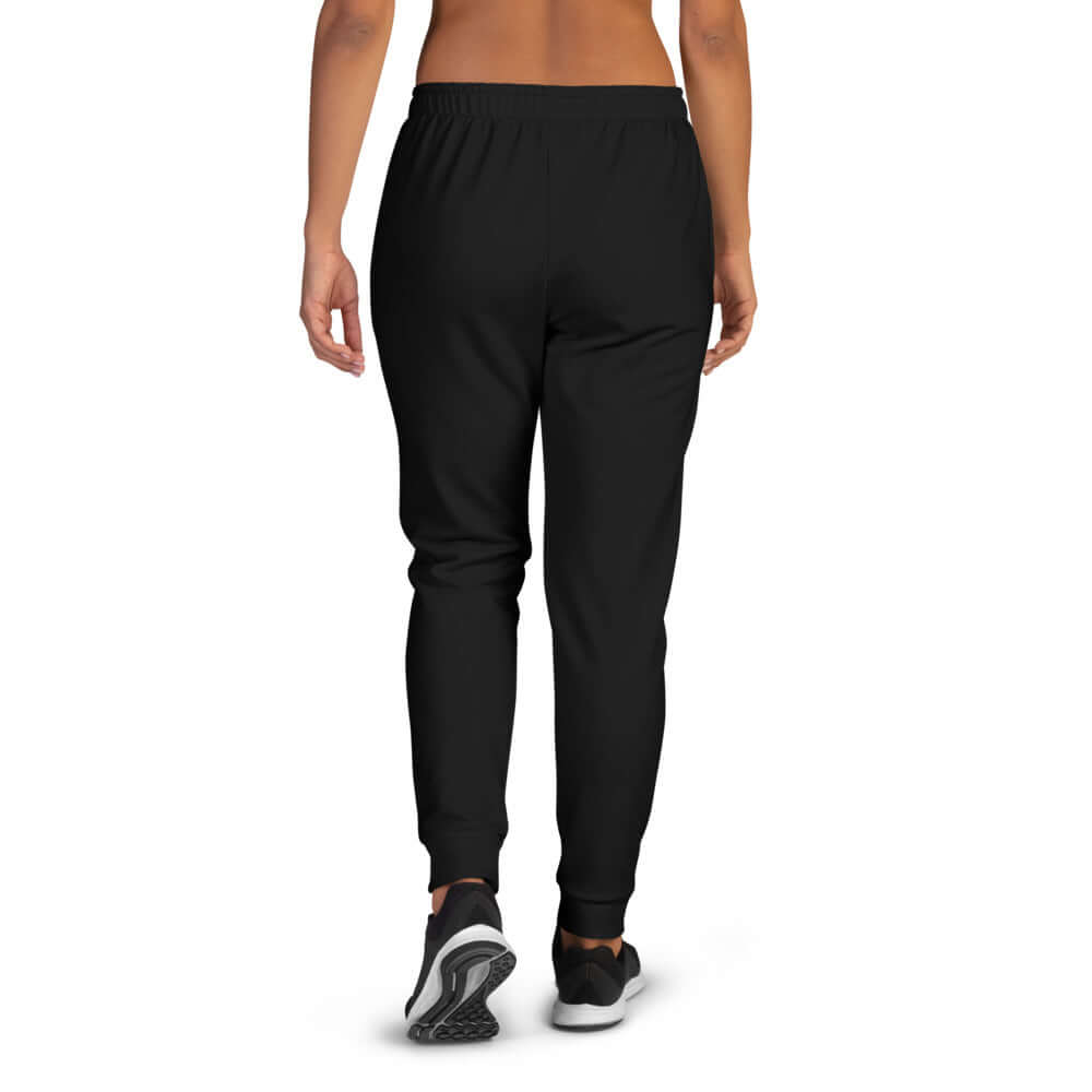 Person wearing Damen-Jogginghose N°1 in black with cuffed legs, made of soft fabric. Back view showing fit and comfort.