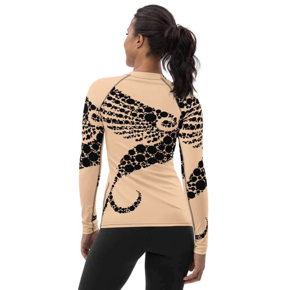 Back view of woman wearing Damen-Rash-Guard N°6, long-sleeve sport top with black pattern on beige, provides UV protection and comfort.