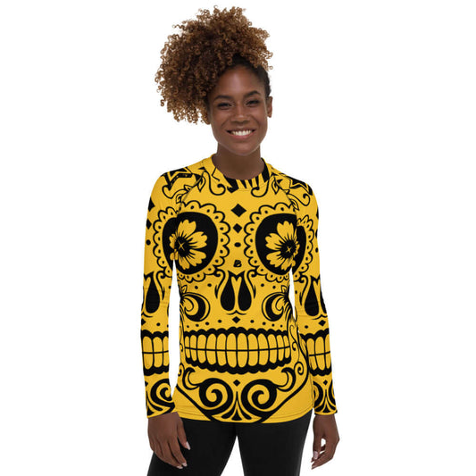 Female model wearing Damen-Rash-Guard N°5 with yellow sugar skull design, long sleeves, UV protection, ideal for active sports.