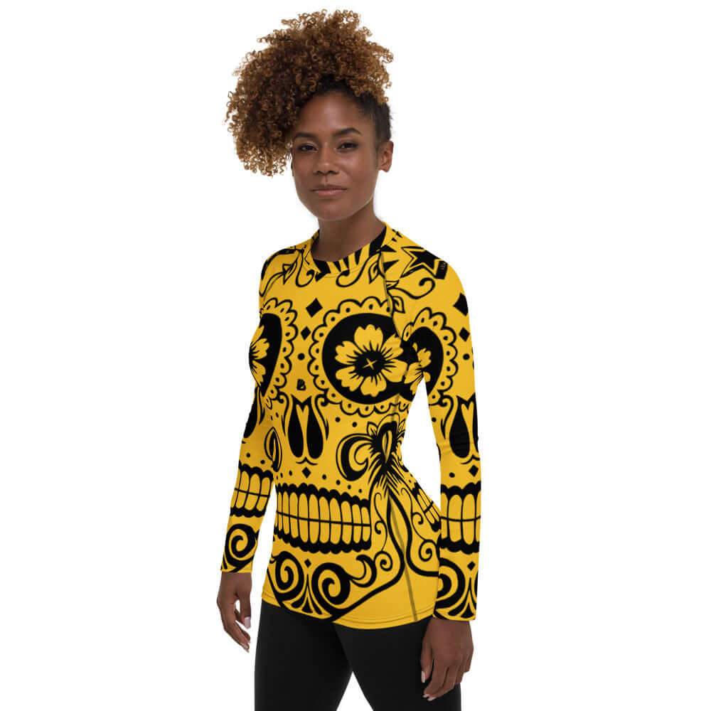 Woman wearing Damen-Rash-Guard N°5, yellow with black skull design, long-sleeve, form-fitting sportswear with UV protection.