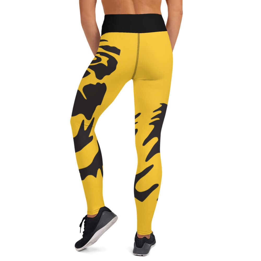 Person wearing yellow and black patterned Yoga-Leggings N°37 with high waistband, showcasing four-way stretch and comfort.