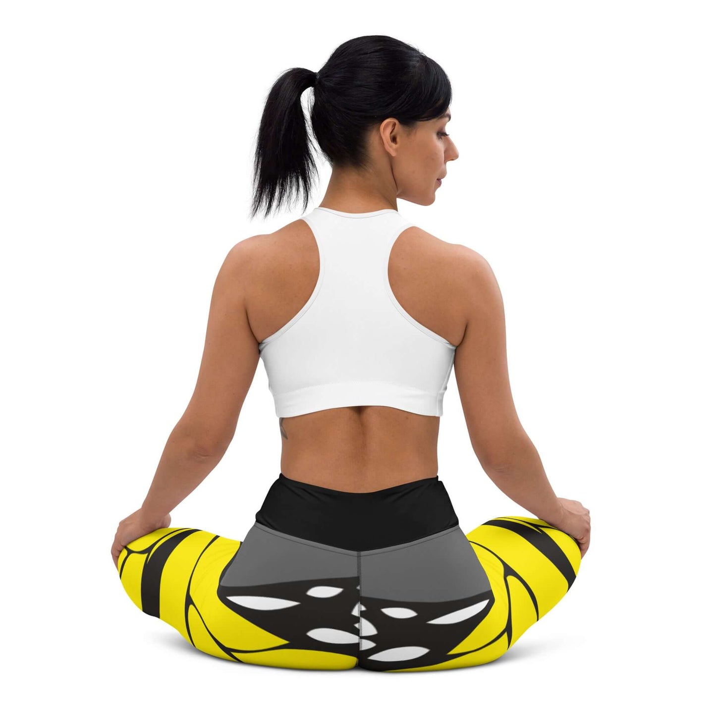 Woman wearing Yoga-Leggings N°41 sitting cross-legged, showcasing stretchy and comfortable design with a vibrant yellow and black print.