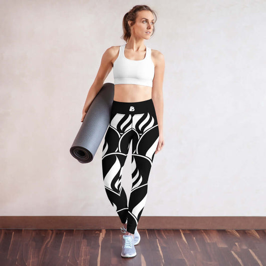 Woman wearing Yoga-Leggings N°19 with abstract black and white design holding a yoga mat in a studio setting.