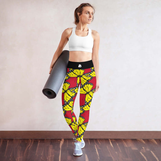 Woman wearing Yoga-Leggings N°27 with butterfly pattern holding a yoga mat in bright room