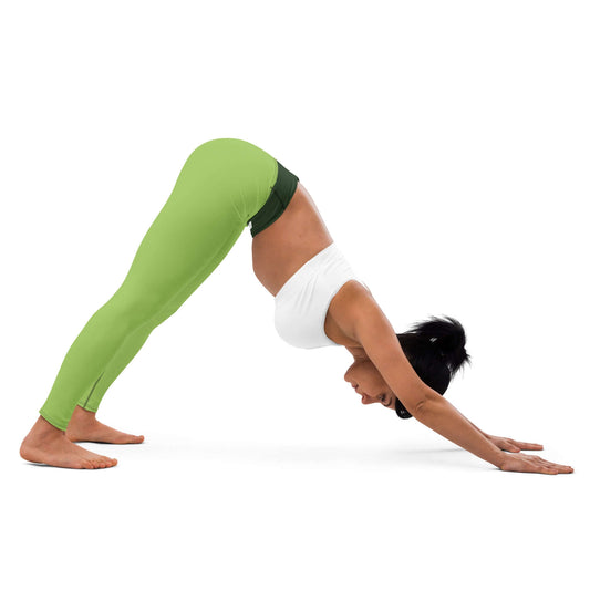 Woman practicing yoga in green Yoga-Leggings N°43, demonstrating downward dog pose.