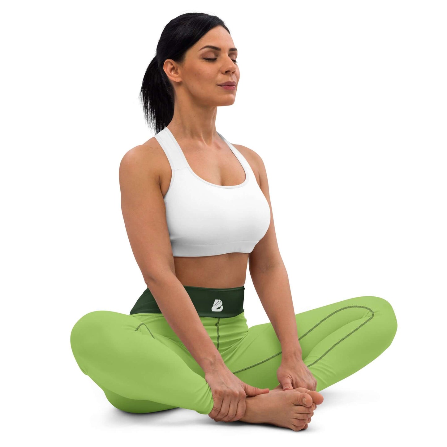Woman practicing yoga in green Yoga-Leggings N°43 with white sports bra, sitting in a lotus position